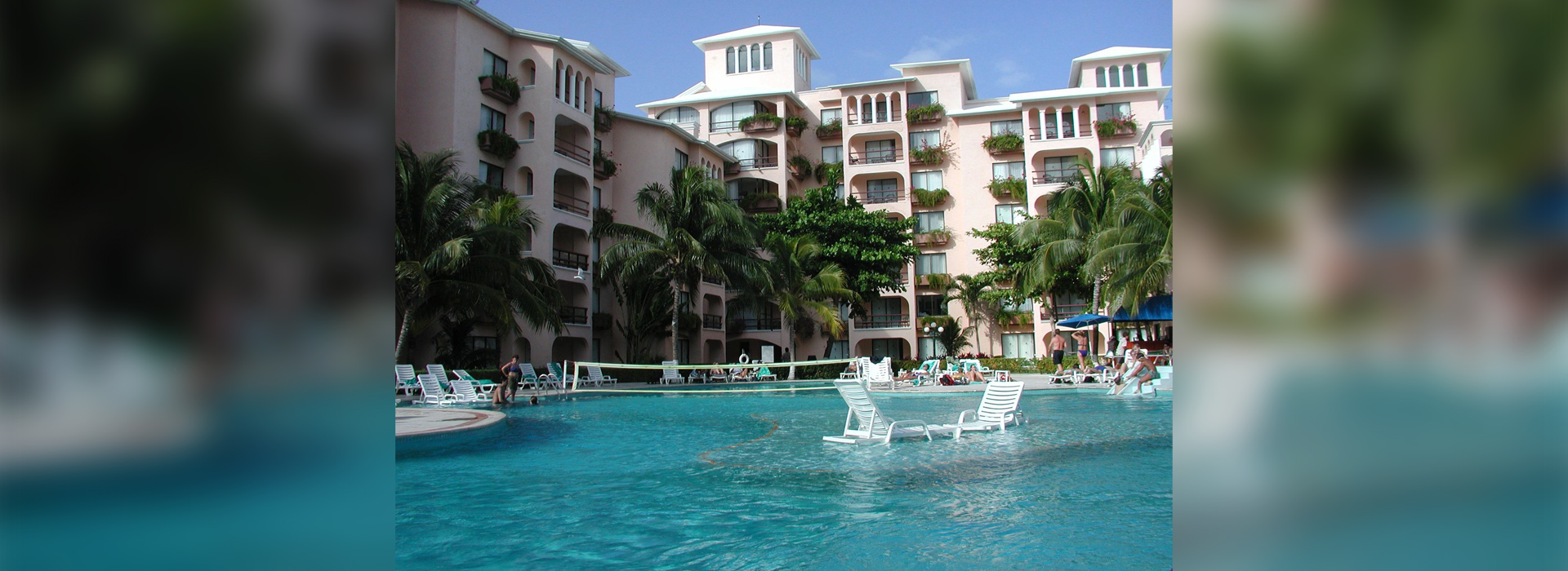 A pool with chairs and volleyball net in it.