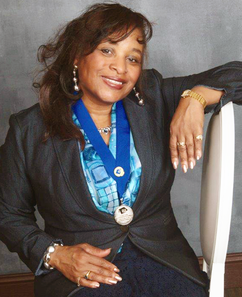 A woman sitting on top of a chair wearing a blue ribbon.